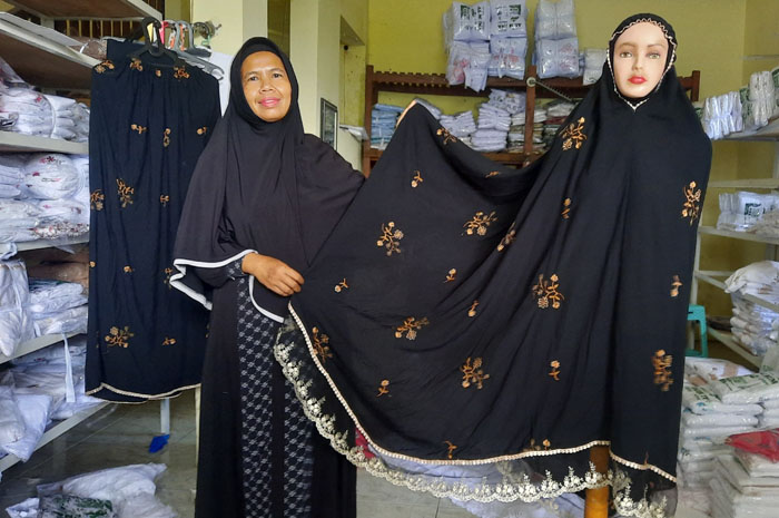 PRODUSEN MUKENA: Noor Saidah memperlihatkan mukena hasil produksinya yang saat ini lagi tren.