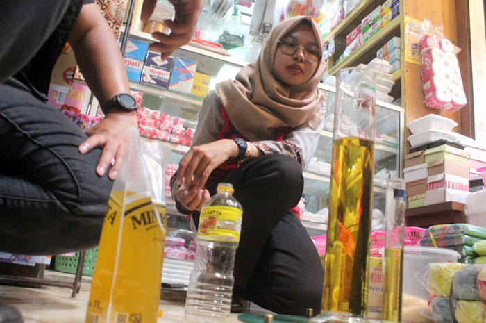 UJI VOLUME: Penguji dari UPTD Metrologi Legal Kabupaten Jepara Puji mengukur minyak goreng Minyakita kemasan botol plastik dan plastik kemarin.