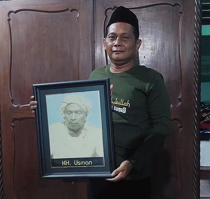 BANGGA: Kiai Anief sedang memegang foto kakeknya Kiai Usman.