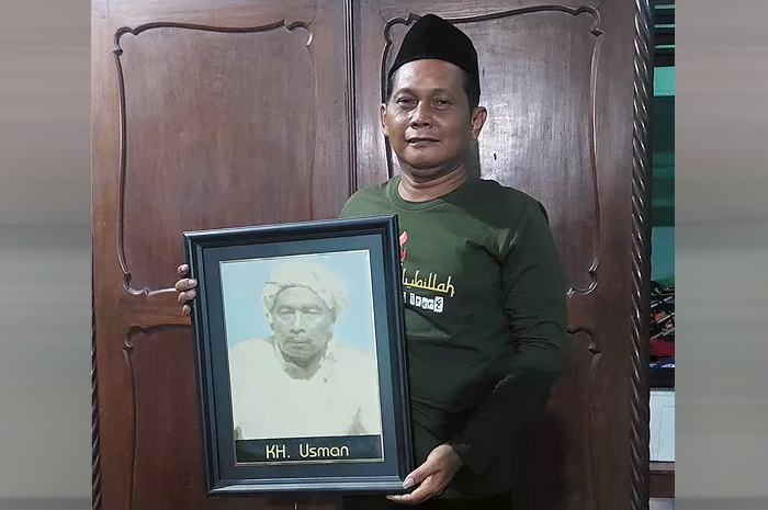 BANGGA: Kiai Anief sedang memegang foto kakeknya, Kiai Usman.