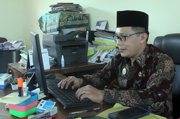 OLAH DATA: Analisis SDM di Bidang Pendidik dan Tenaga Kependidikan (PTK) Adi Hananto tengah meninjau keakuratan data.