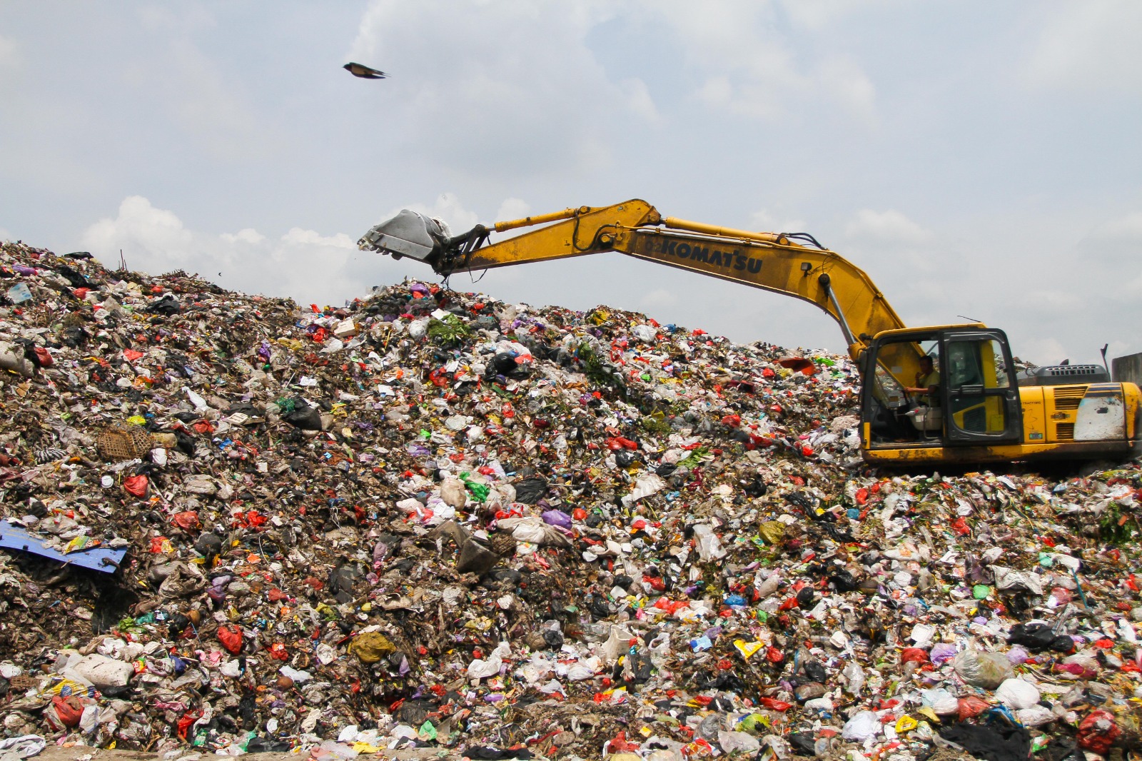 MASIH MENUMPUK: Pekerja memindahkan tumpukan sampah yang berada di TPA Tanjungrejo pada Minggu, 16 Maret 2025.