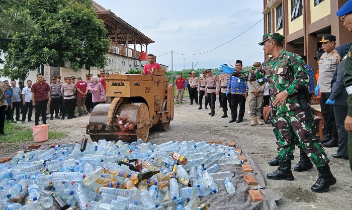 HANCURKAN: Polres Blora saat memusnahkan miras yang didapat selama razia.