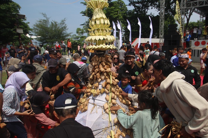 BAWA BERKAH: Masyarakat berebut ketupat dan lepet yang terpasang di gunungan dalam agenda Festival Kupat Lepet di Pantai Kartini Jepara.