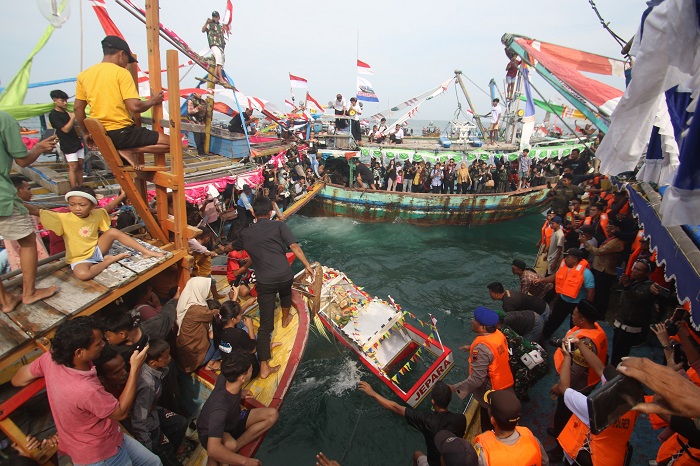 NEKAT: Warga menceburkan diri untuk bisa berebut sesaji yang baru saja dilarung oleh jajaran Forkopimda Jepara.