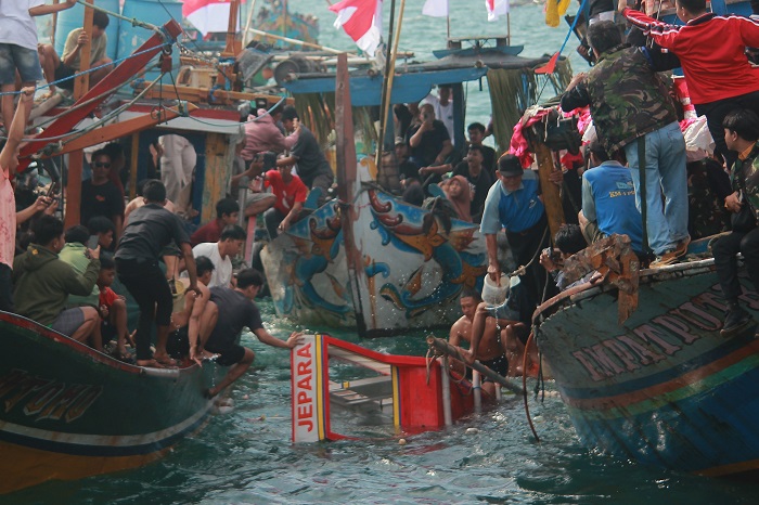 NEKAT: Warga menceburkan diri untuk bisa berebut sesaji yang baru saja dilarung oleh jajaran Forkopimda Jepara.