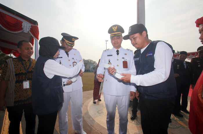 INOVATIF: Bupati dan Wakil Bupati Jepara Witiarso Utomo dan M. Ibnu Hajar akan mencoba alat pembayaran nontunai yang akan dipakai dalam program e-ticketing di objek wisata milik Pemkab Jepara kemarin.