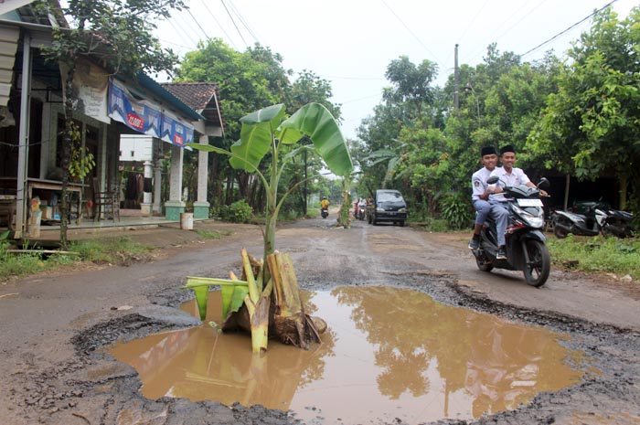 MENGANGA: Kondisi lubang di Jalan Desa Dongos yang membahayakan kemarin.