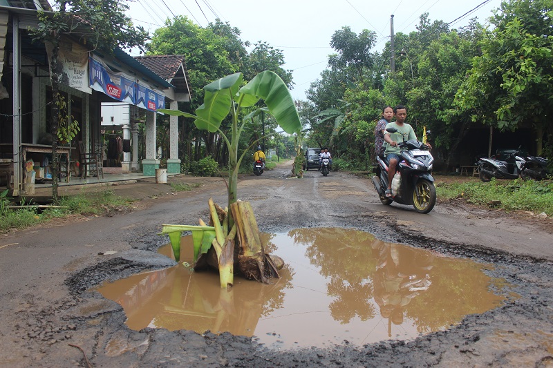 MENGANGA: Kondisi lubang di Jalan Desa Dongos yang membahayakan.