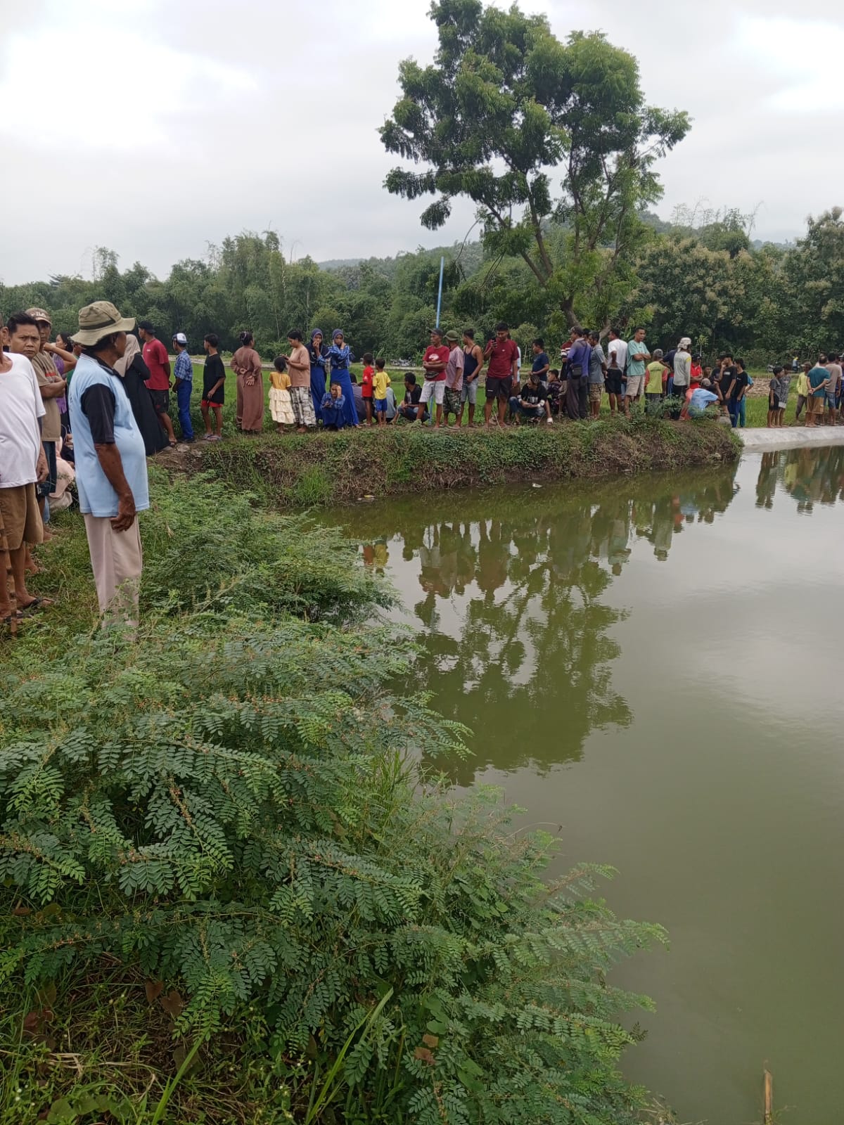 SHOCK: Orang tua  korban anak tenggelam shock saat berada di  lokasi embung Warugunung.