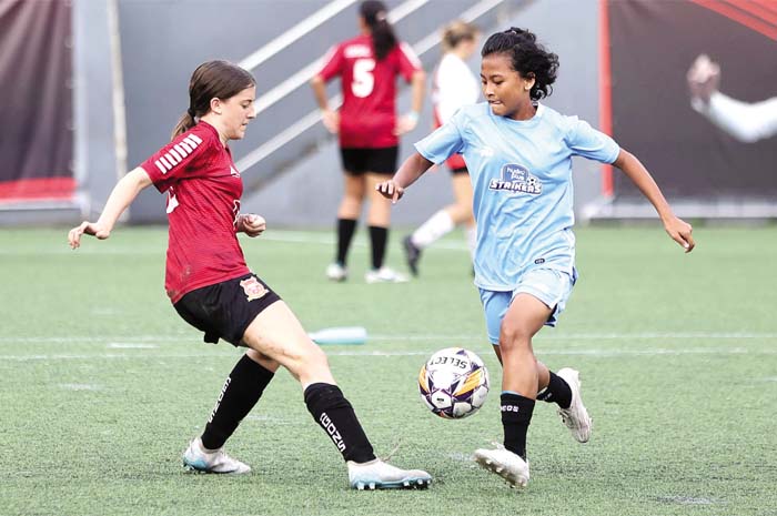 HARUMKAN BANGSA: Pesepakbola putri Della Citra (kanan) berebut bola dengan lawannya di ajang JSSL Singapura.