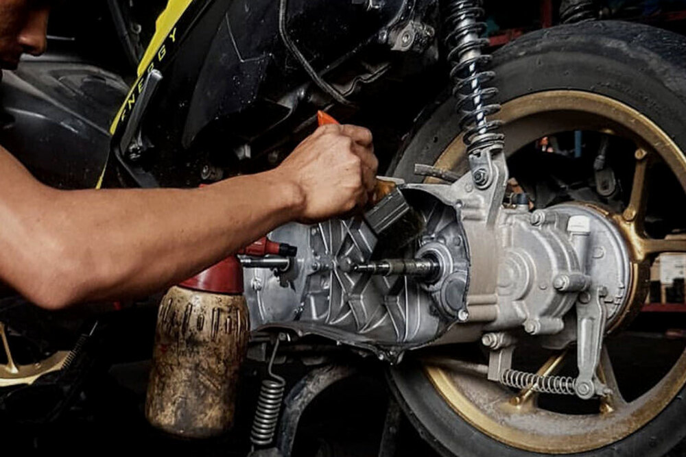 PERAWATAN: Montir sedang melakukan perawatan pada motor matic.