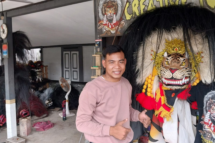 KREATIF: Muhamad Taufiq, pembuat barongan khas Blora berfoto di samping salah satu karyanya.