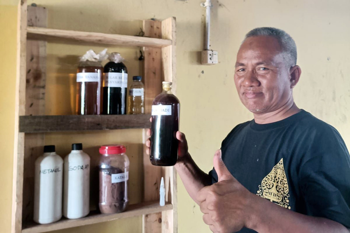 MENUNJUKKAN: Direktur BUMDes Kuwariron Jaya Ali Sadzali saat menunjukkan hasil pengolahan sampah menjadi BBM.