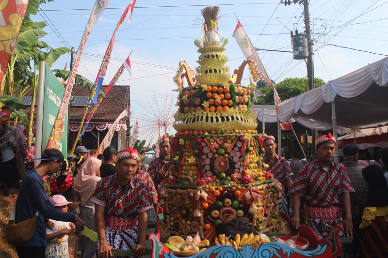 MERIAH: Gunungan persembahan dari warga dikirab dalam sedekah bumi kemarin.