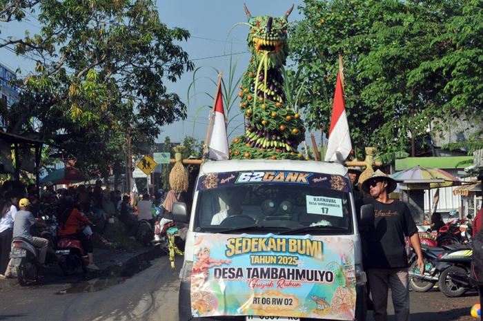 KELILING: Warga Desa Tambahmulyo, Jakenan mengarak gunungan di jalan desa akhir pekan lalu.