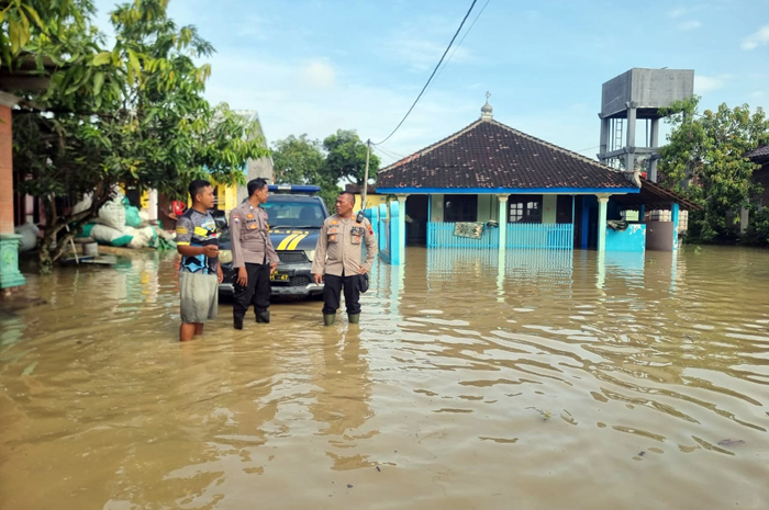 TERENDAM BANJIR: Anggota Polsek Tegowanu melakukan pengawasan di Desa Sukorejo, Kecamatan Tegowanu.