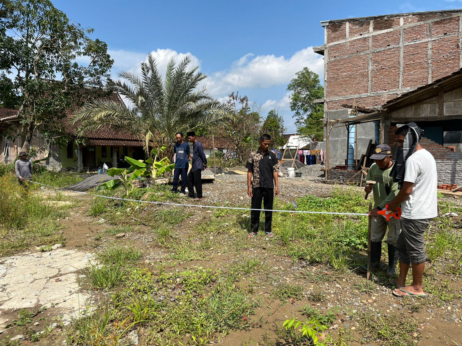 MENGUKUR: Petugas dari REI saat mengukur lahan untuk pembangunan rumah rusak di Desa Baturagung Kecamatan Gubug.