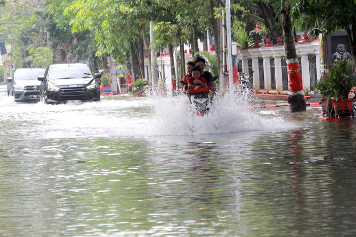 TERJANG BANJIR: Seorang pengendara sepeda motor sedang menerjang banjir yang menggenangi jalan di alun-alun Purwodadi depan Pendopo Kabupaten, Kamis (22/5).