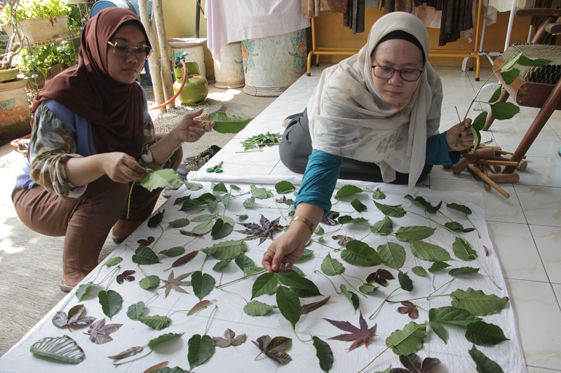 PROSES: Nunung Noor Khamimah perajin ecoprint saat Menyusun daun-daun diatas kain putih untuk memperlihatkan proses pembuatan ecoprint di rumahnya.