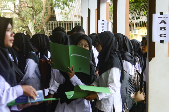 Peserta mengecek isi SK pengangkatan CPNS yang baru mereka terima.