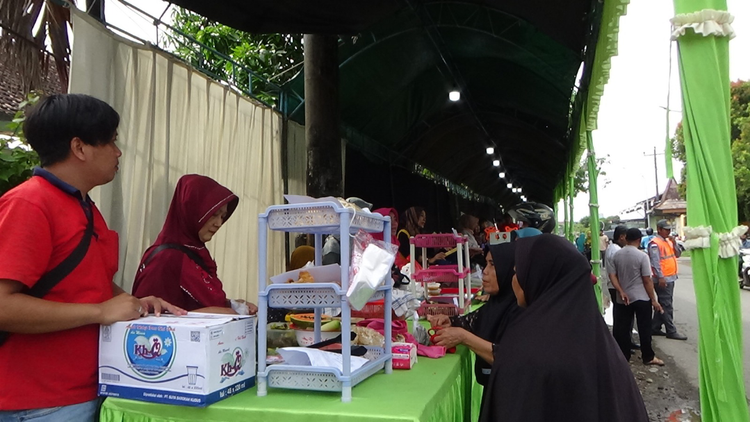 TRANSAKSI: Pengunjung membeli sejumlah produk dari pelaku UMKM desa setempat di Expo UMKM Jati Wetan, kemarin. (ANDIKA TRISNA SAPUTRA/RADAR KUDUS)