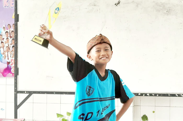 BANGGA: Adinata Haidar Achmad menenteng tropi juara I FTB Jateng 2024 di kelasnya.