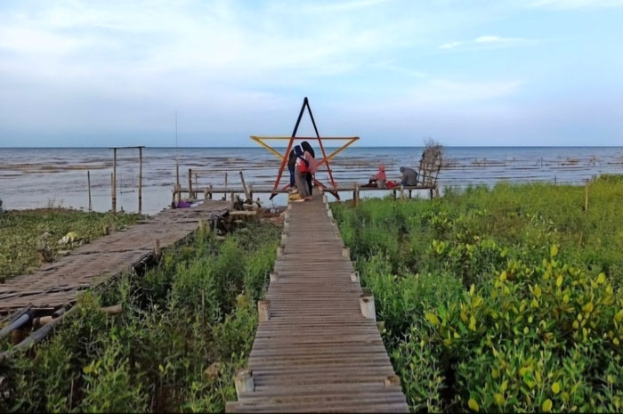LIBURAN: Masyarakat berdiri di mangrove pesisir pantai Pati belum lama ini, rob yang menghantam wilayah pantai mengakibatkan hutan mangrove rusak.