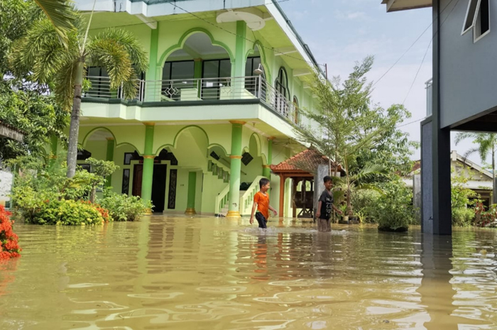 TERGENANG: Anak-anak di Desa Tunggulsari, Tayu beraktifitas di tengah banjir belum lama ini.