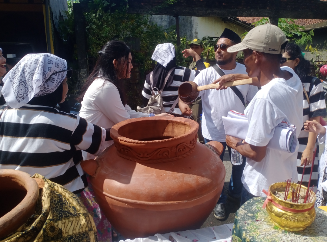TRADISI: Warga setempat yang mengikuti Kirab Grebeg Suro meminta air dari punden yang telah didoakan secara kolektif di depan Balai Desa Tumpangkrasak, pagi ini. (ANDIKA TRISNA SAPUTRA/RADAR KUDUS)