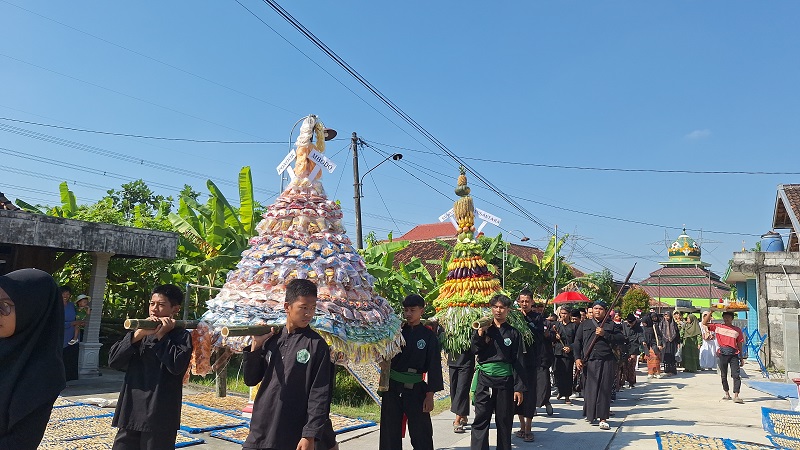 KIRAB GUNUNGAN &ndash; Warga Dusun Sendangsari, Desa Tambirejo, Kecamatan Toroh membawa gunungan dalam kirab pusaka dan jamasan.