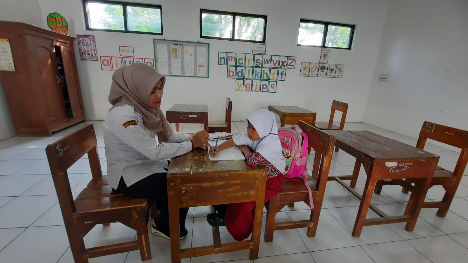 INDAH SUSANTI/RADAR KUDUS BELAJAR: Shifa siswa kelas I  SD 5 Jurang saat mengikuti MPLS yang didampingi wali kelasnya kemarin.