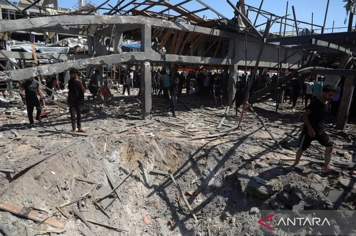 Warga berdiri di kafe pinggir pantai Al-Baqa Cafeteria yang dihancurkan Israel melalui serangan udara di Kota Gaza, Palestina, Minggu (30/6/2025).