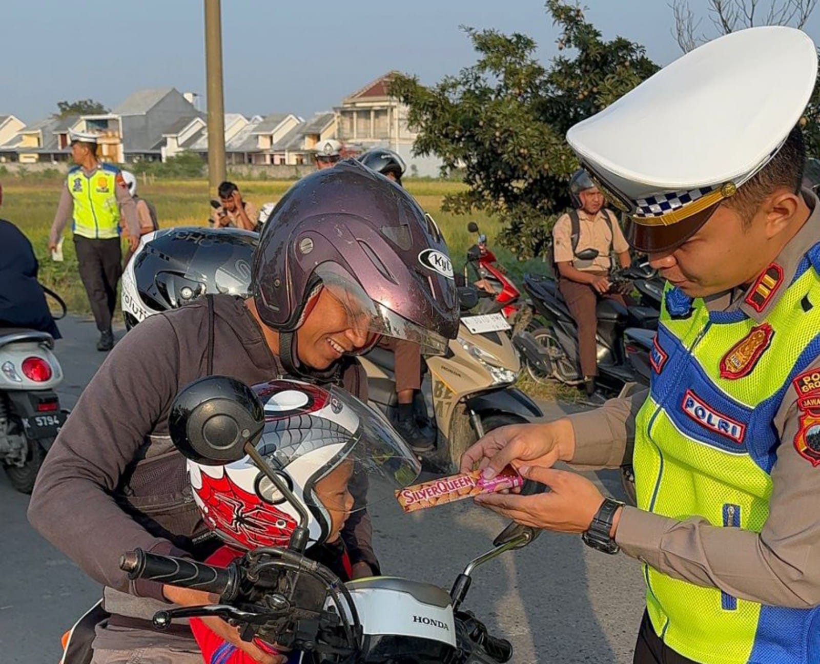 REWARD: Satlantas Polres Grobogan saat memberikan cokelat ke pengendara yang tertib berlalu lintas.