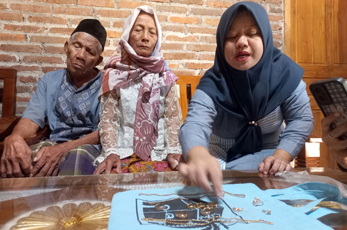 IMITASI: Sukarti didampingi oleh sang suami Suhadi menunjukkan perhiasan simpanannya yang berubah jadi mainan Senin (21/7).