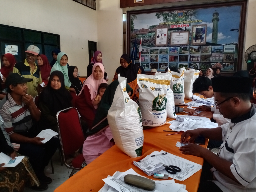 ANTRE PANJANG: Sejumlah warga Ngembalrejo mengantre untuk mengambil bantuan pangan beras di Aula Balai Desa Ngembalrejo, pagi ini. (ANDIKA TRISNA SAPUTRA/RADAR KUDUS)