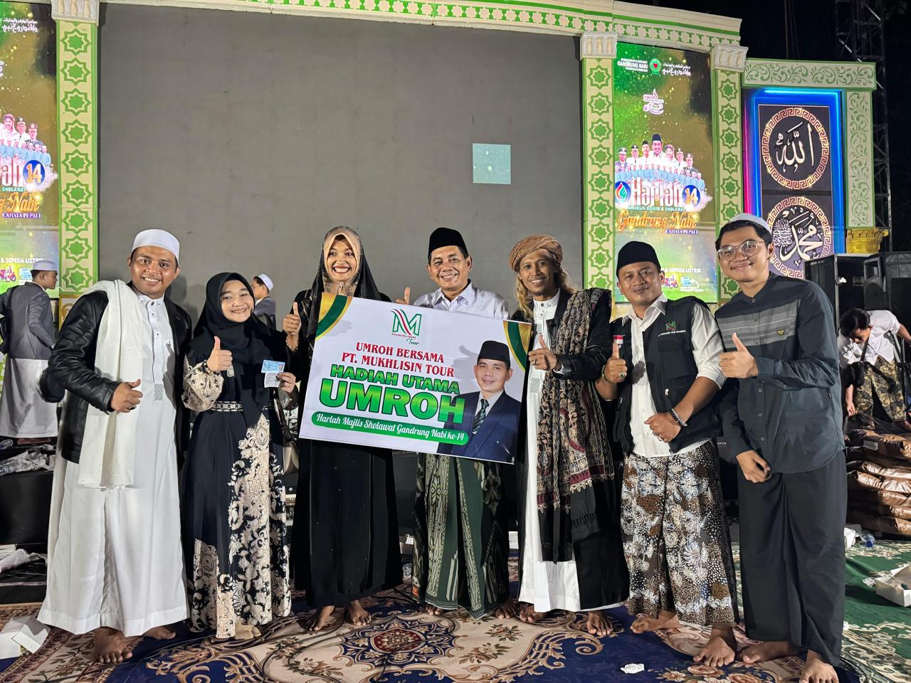SERAHKAN HADIAH &ndash; Pimpinan PT Mukhlisin Tour Indonesia Mukhlisin menyerahkan hadiah Umroh Gratis kepada Nur Mela Hayati di acara Harlah ke-14 Gandrung Nabi di alun-alun Purwodadi.
