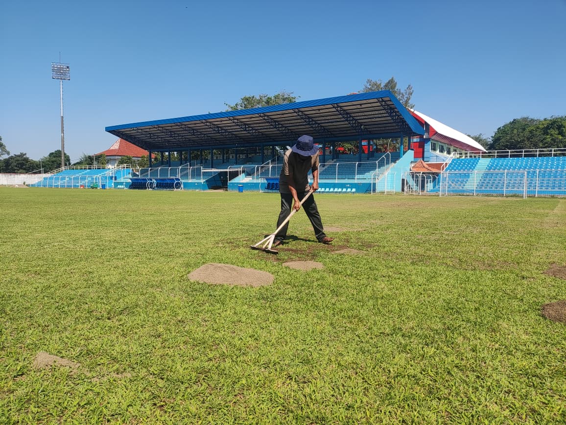 DIRATAKAN: Pekerja sedang melakukan penaburan pasir di atas lapangan Stadion Wergu Wetan.