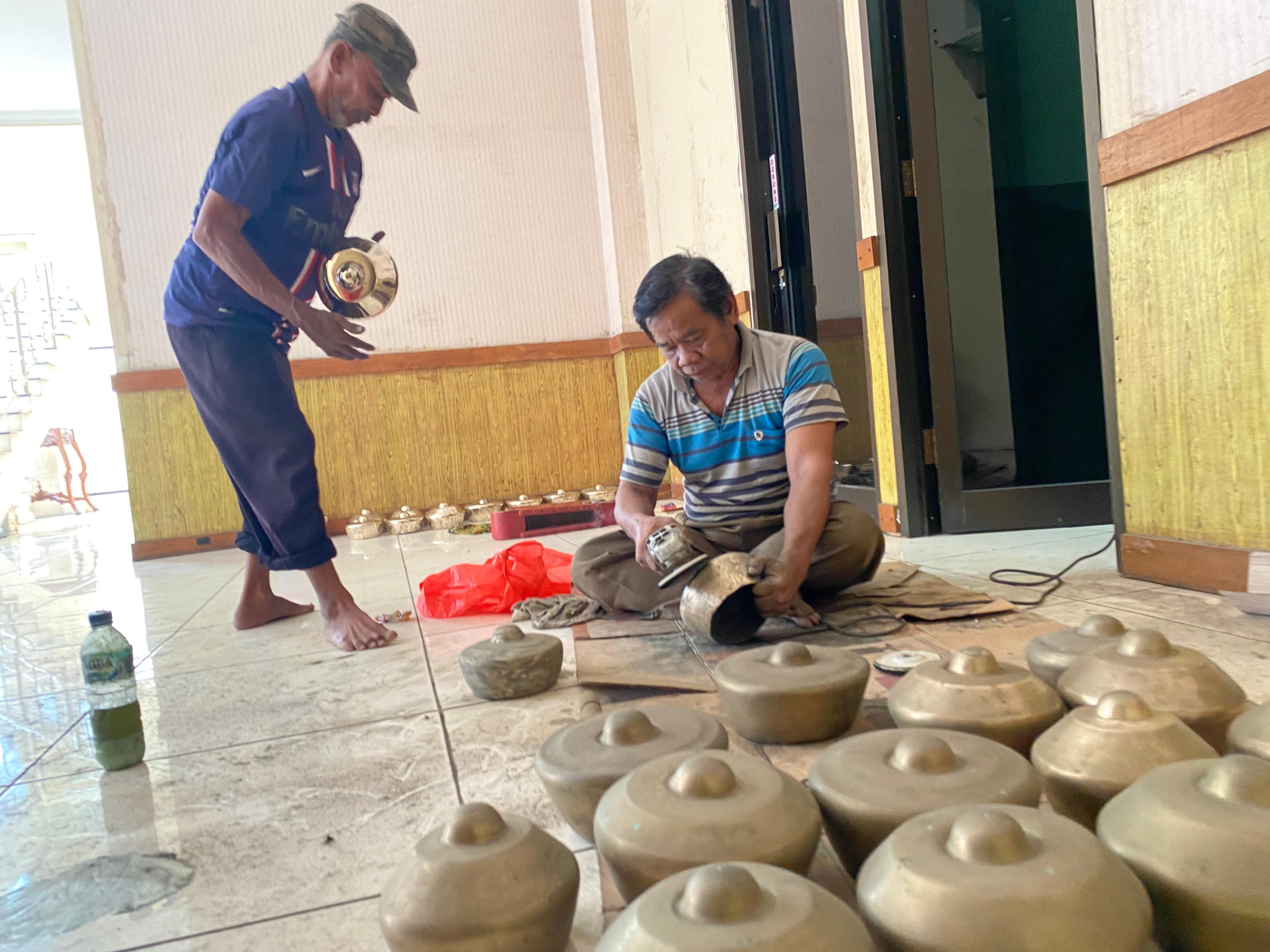 BERSIHKAN: Terlihat dua orang sedang membersihkan gamelan yang telah lama tidak dipakai, Senin (4/8). (ANDIKA TRISNA SAPUTRA/RADAR KUDUS)