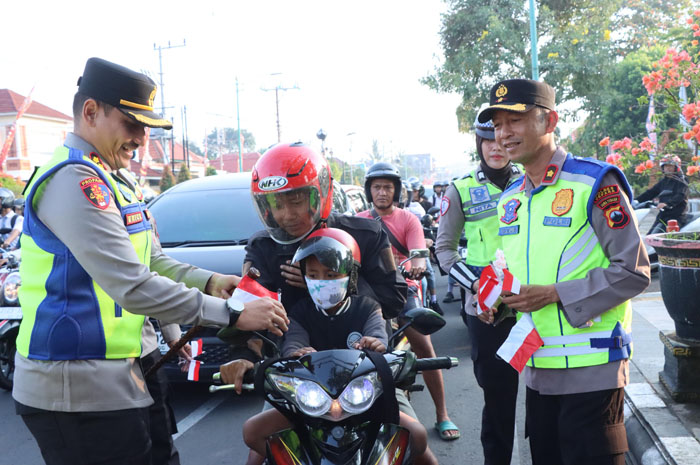 Kapolres AKBP Erick Budi Santoso bersama Pejabat Utama (PJU) dan personel Polres Jepara membagikan bendera kepada pengendara yang melintas di&nbsp;kawasan Jalan Kartini dan Jalan Pemuda, pada Selasa (5/8).