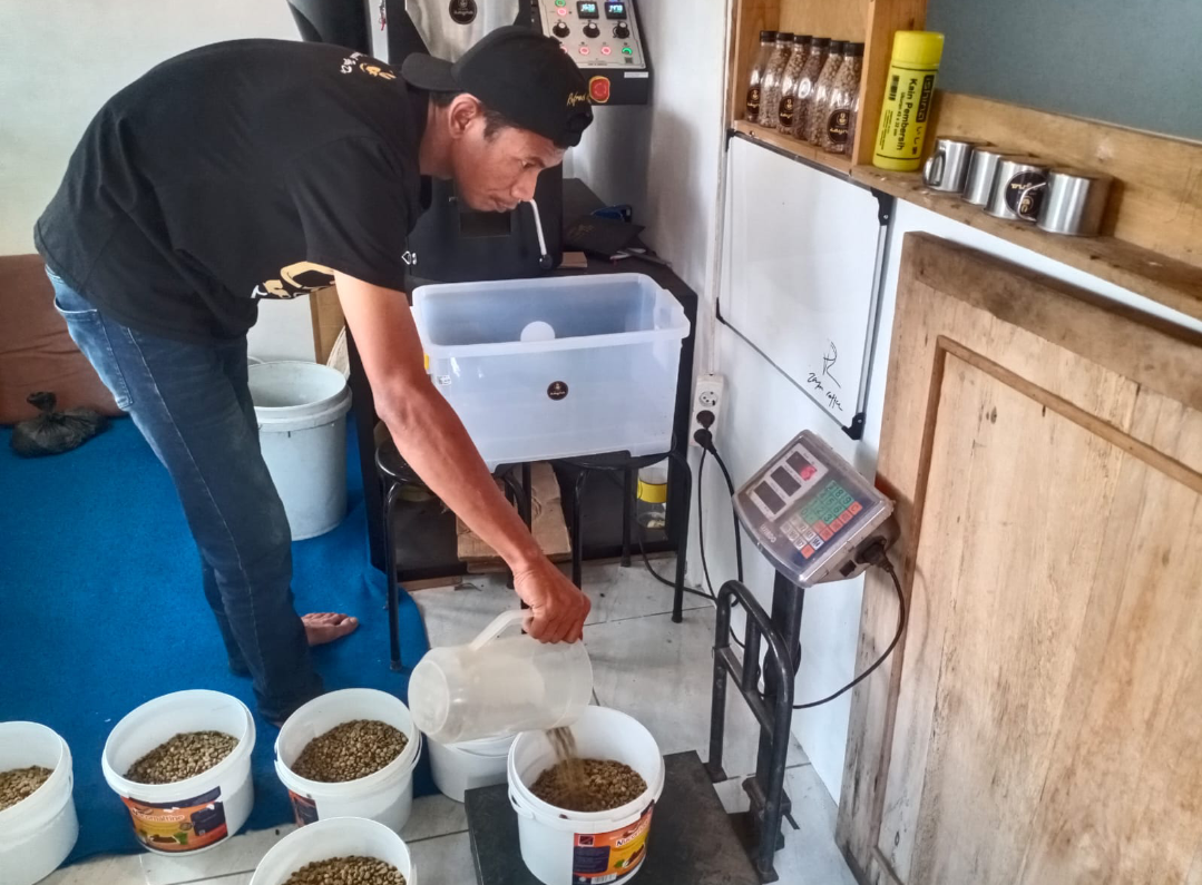 TIMBANG: Salah satu pelaku UMKM kopi sedang menimbang biji kopi ke dalam wadah, sore ini. (ANDIKA TRISNA SAPUTRA/RADAR KUDUS)