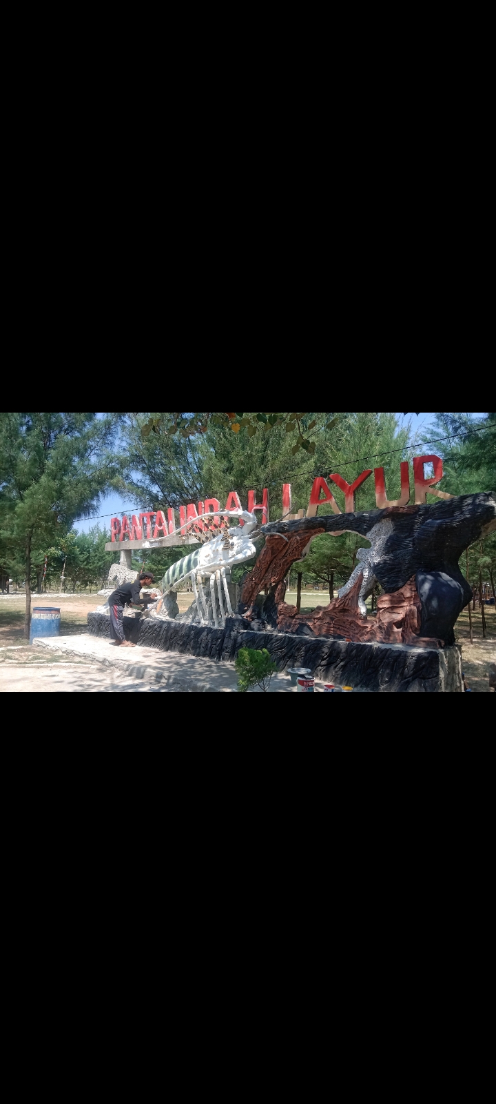 Pengelola Wisata Pantai Indag Layur sedang mengecat patung.