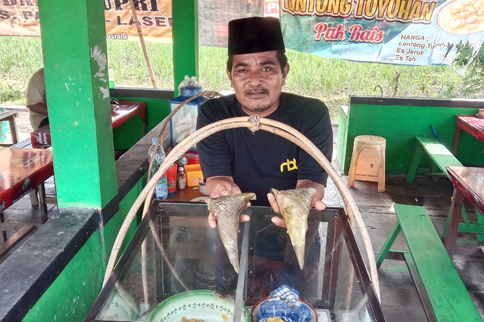 CIRI KHAS: Rais, pedagang lontong tuyuhan menunjukkan lontong berbentuk segitiga.