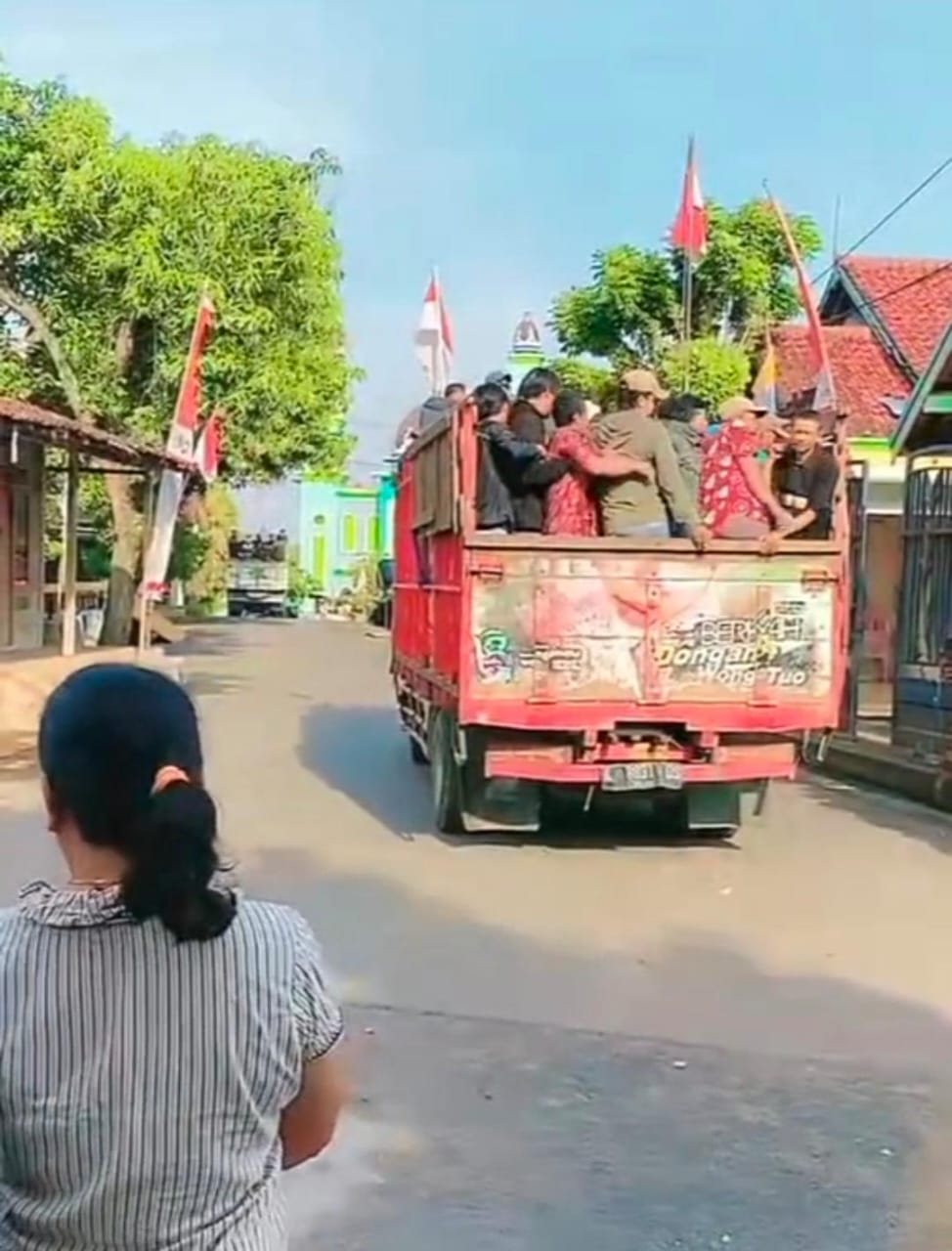 BERANGKAT: Warga Pati naik bak truk terbuka disaksiskan para emak-emak.