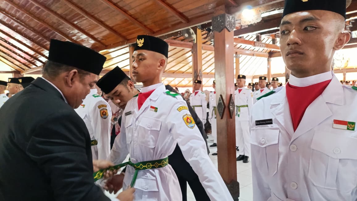 DIKUKUHKAN &ndash; Bupati Grobogan Setyo Hadi mengukuhkan anggota Paskibraka yang bertugas dalam upacara HUT RI Ke 80 di alun-alun Purwodadi