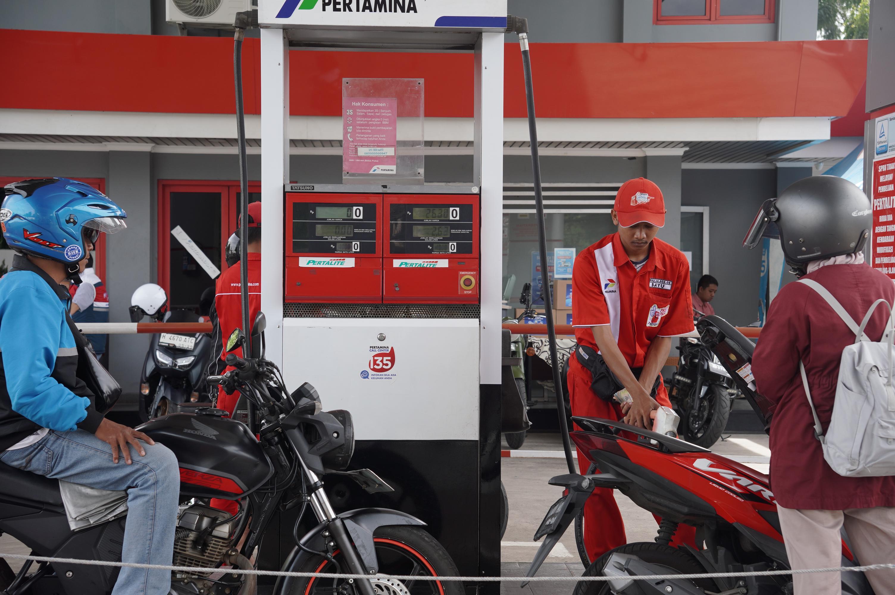 ISI BBM: Petugas SPBU mengisi bahan bakar pada konsumen.