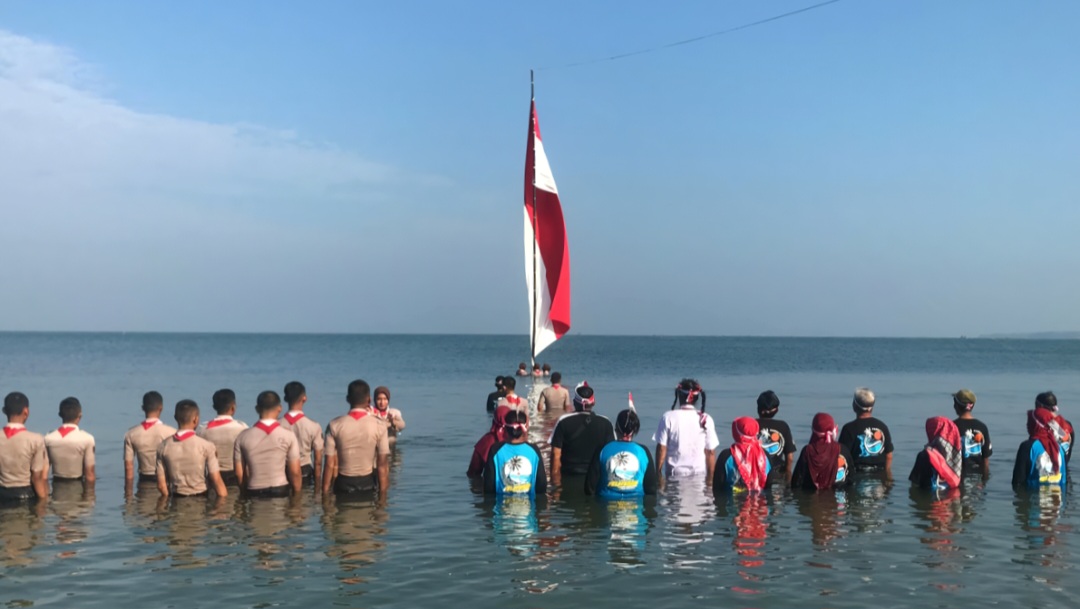 TOTALITAS: Sejumlah warga dan siswa tengah melakukan upacara di Pantai Pelayaran Kelurahan Karangkebagusan Kecamatan Jepara pada Minggu (17/8).
