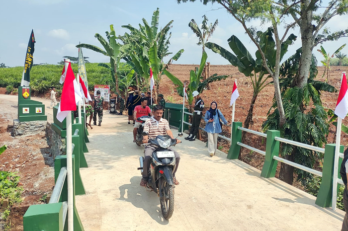 BERMANFAAT: Warga melintasi jembatan yang menjadi sasaran fisik TMMD Reguler ke-125 di Desa Kandangmas.