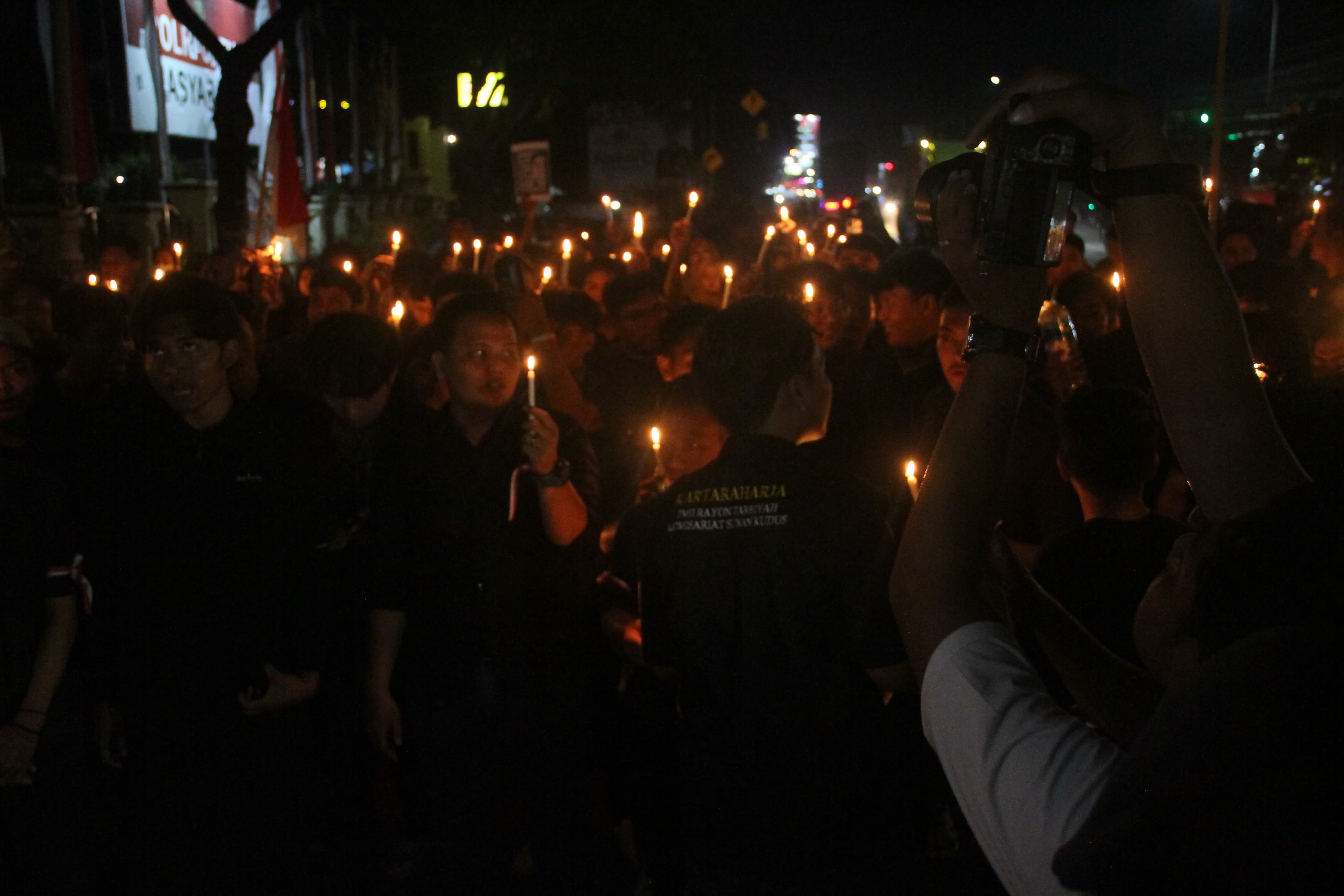 TURUT BERDUKA: Mahasiswa bersama seluruh pejabat yang hadir menyalakan lilin dan doa bersama di depan Mapolres Kudus, Jumat (29/8) malam. (GALIH ERLAMBANG W/RADAR KUDUS)