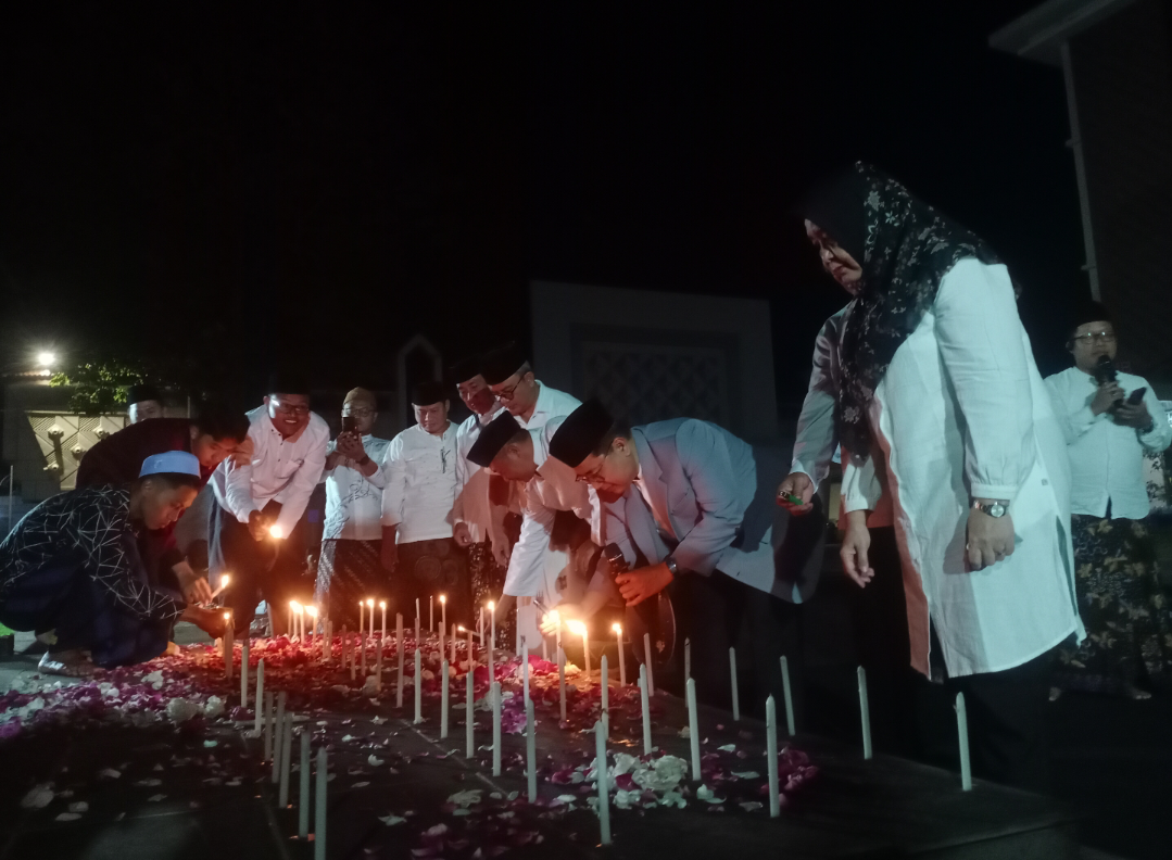 PENGHORMATAN: Civitas akademika UMK menyalakan puluhan lilin dan menabur bunga atas tragedi ojol dan negara, malam ini. (ANDIKA TRISNA SAPUTRA/RADAR KUDUS)